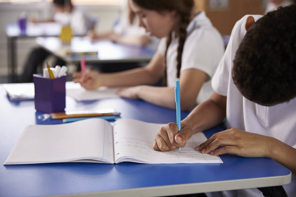 Students working quietly in a classroom during an academic writing exercise